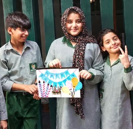 Three older primary pupils in RMS uniform standing together in class