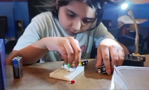 A pupil placing components on a breadboard during a robotics lesson