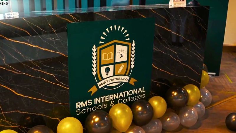 The RMS International reception desk with the school crest, decorated with gold and black balloons to welcome visitors