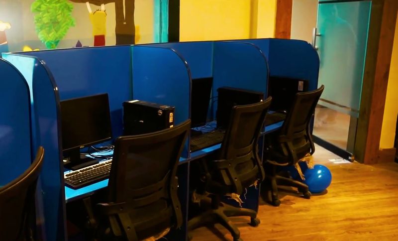 The computer lab with blue study booths, desktop computers and a projector.